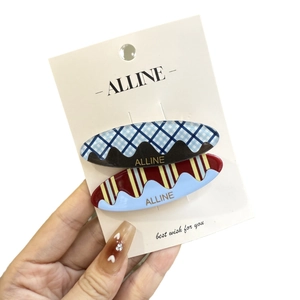 Set of two vintage checkered hair clips with wavy patterns on white card display