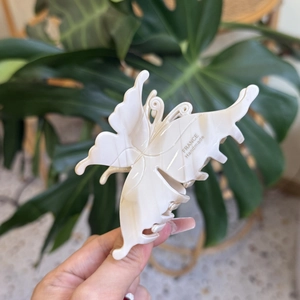 Pince à cheveux papillon élégante en acétate crème marbré avec détail d'étiquette dorée