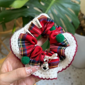 Détail du chouchou de Noël à carreaux avec dentelle rouge, pompons verts et petit grelot