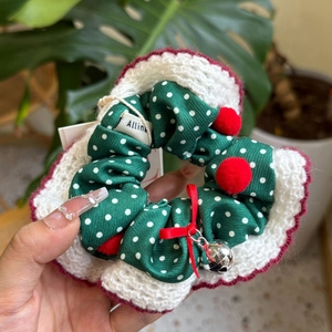 Détail d'un chouchou de Noël festif avec dentelle au crochet et petite cloche argentée
