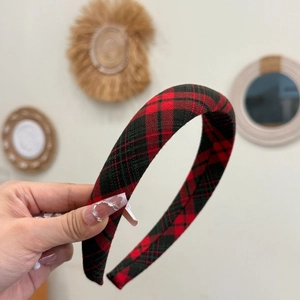 Détail d'un serre-tête de Noël à carreaux rouges et noirs avec finition en tissu doux