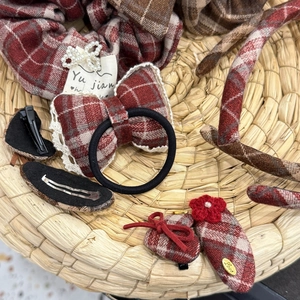 Macro shot of red plaid hair accessories set featuring pearl bows and vintage clips