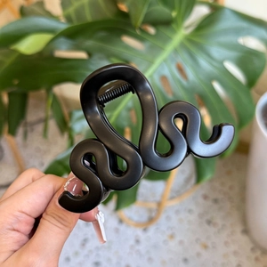 Détail d'une grande pince à cheveux S-wave noire mate avec ressort métallique robuste