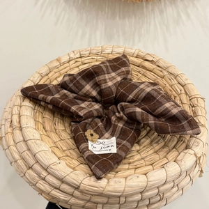 Brown plaid bow hair scrunchie with handmade crochet flower and woven label in a basket
