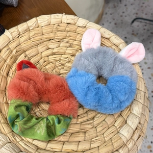 Cute plush animal hair scrunchies with fox and bunny ear designs in a woven basket