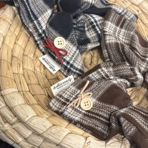 Detail of plaid fabric accessory with wooden button and bow on a woven basket