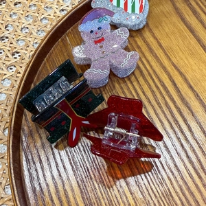 Vue détaillée de pinces à cheveux de Noël pailletées avec motifs de bonhomme en pain d'épices