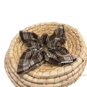 Brown and white checkered tweed bow hair tie on a rustic straw woven plate