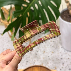 Macro detail of large red and green plaid hair claw clip with glossy finish