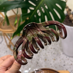 Octopus style claw clip with dark green and red plaid pattern and star print details