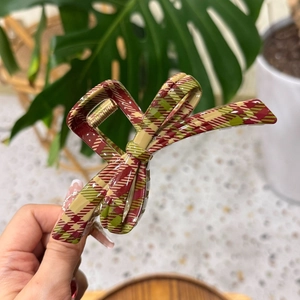 Detailed view of large red and green plaid hair claw clip with golden metal spring