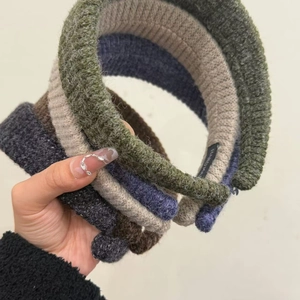 Detailed close-up of five knitted ribbed headbands in assorted earthy tones with handmade tags