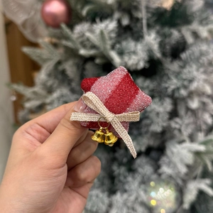 Close-up of red and silver star ornament with champagne bow and golden bells