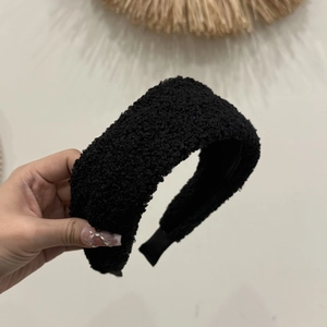 Vue macro détaillée montrant la texture douce et le grain épais du serre-tête noir en polaire