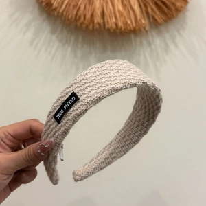 Modisches Strickstirnband in Beige mit Stoffetikett für elegante Damenhairstyles