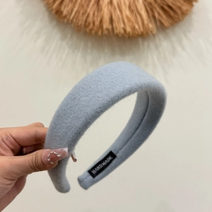 Detailed macro view of handmade wool felt light blue padded headband with label