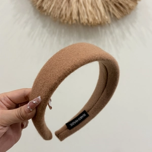 Close-up of camel wool headband featuring a handmade fabric label for autumn winter