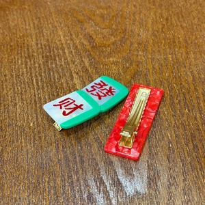 Dettaglio dei fermagli per capelli del Capodanno Cinese con motivo mahjong e marmo rosso