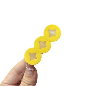 Fermaglio per capelli in acrilico giallo con intarsi di stelle in madreperla