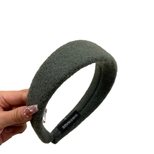 Wide dark green wool headband for women with a plush texture and handmade label