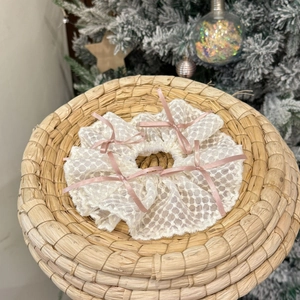 Gros plan d'un chouchou en dentelle blanche avec des nœuds roses en décor de fête