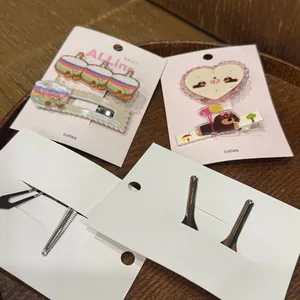 Détail de pinces à cheveux gâteaux avec motifs arc-en-ciel et cœurs sur plateau bois