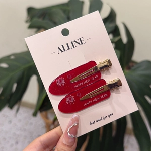 Paire de pinces à cheveux rouges festives avec texte Happy New Year sur carte