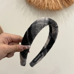 Detailansicht des handgefertigten Woll-Haarreifs mit Karo-Muster und Hand-Made-Etikett