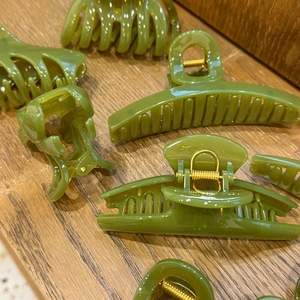 Detail shot of assorted green hair claw clips in various elegant resin designs