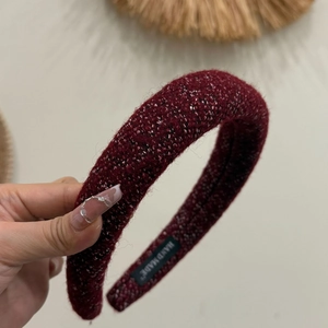 Close-up of handmade burgundy tweed padded headband with detailed woven texture