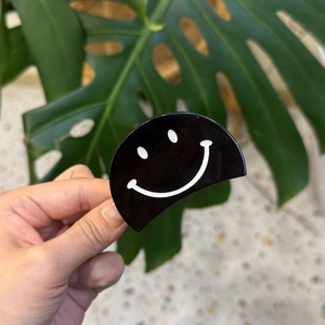 Pince à cheveux minimaliste en acétate noir avec un motif de visage souriant blanc mignon