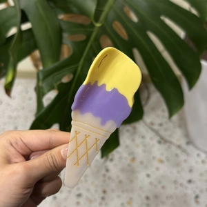 Close-up of ice cream acetate hair claw with yellow and purple layers and gold grid details