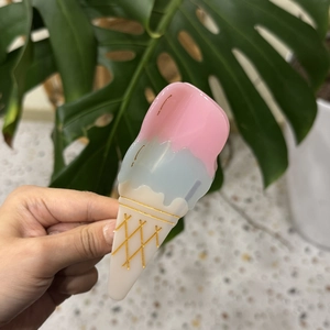 Detail of ice cream shape hair claw with pastel colors and golden texture details