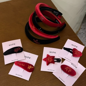 Detail view of festive red and black velvet headband and embroidered hair clip sets