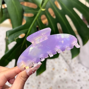 Détail d'une grande pince à cheveux en acétate violet avec réfraction laser colorée