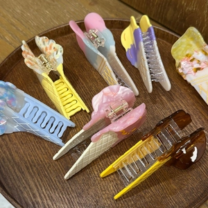 Macro shot of colorful ice cream cone hair claws in pastel pink, yellow, and blue shades