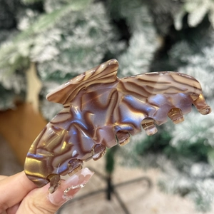 Détail d'une grande pince à cheveux en acétate avec motif marbré coloré et éclat métallique