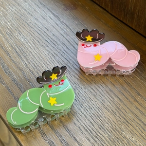 Gros plan de pinces à cheveux chenille avec chapeaux de cow-boy en vert et rose
