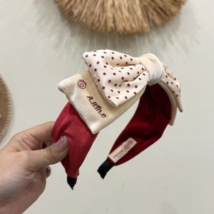 Détail d'un serre-tête en velours rouge avec nœud multicouche et antidérapant