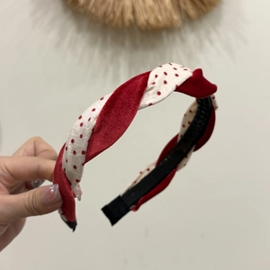Détail du serre-tête torsadé en velours rouge à pois blancs pour coiffures de fête