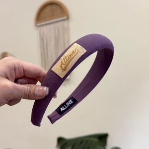 Détail d'un serre-tête violet rembourré avec tissu sergé et broderie Alline élégante