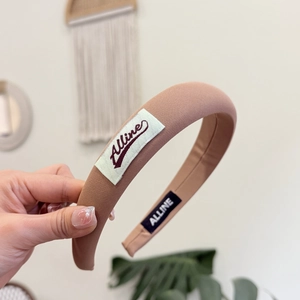 Gros plan du serre-tête en éponge rose avec texture tissée et étiquette de marque blanche
