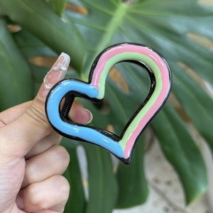 Colorful heart-shaped hair claw clip with pink, green and blue wave design for women