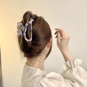 Detail view of purple marble acetate butterfly hair claw clip on a woman's hair