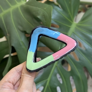 Triangle claw clip with pink, blue, and green wave pattern in a glossy finish