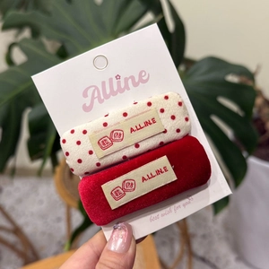 Détail de pinces à cheveux en velours rouge et à pois blancs avec broderie chinoise