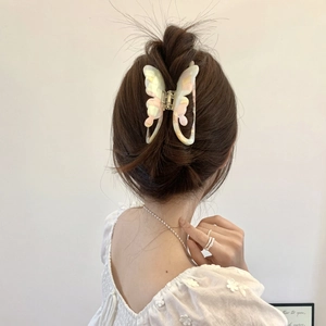 Elegant butterfly hair claw clip shown in a stylish updo on a model, cream pearl finish
