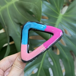 Detailed view of a wave-shaped tricolor shark hair claw clip in vibrant resin finish