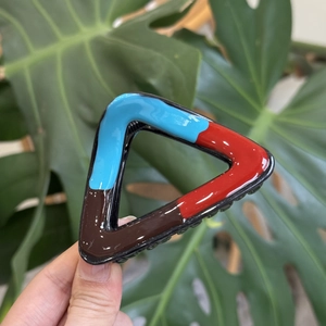 Macro shot of triangular hair claw clip with blue red and brown color blocking design