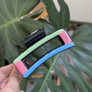 Detail of colorful hollow rectangular hair claw clip with macaron painted accents
